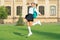 Excited schoolgirl jumping midair, school. Energetic teenage girl carrying school bag. Back to school