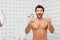 Excited shirtless man holding razors in