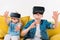 excited siblings using virtual reality headset and sitting