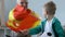 Excited small boy with grandpa watching football match, fans waving Spain flag