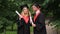 Excited smiling graduates holding diplomas and talking about future in park