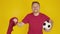 Excited soccer fan celebrating over yellow background