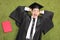 Excited student lying on green grass