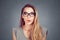 Excited stunned woman in eyeglasses isolated on the  grey background