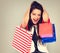 Excited surprising shouting woman with opened mouth in fashion white dress with shopping bags. Happy New Year Holidays sales