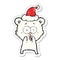 excited teddy bear hand drawn distressed sticker cartoon of a wearing santa hat