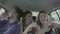 Excited teen friends enjoying car ride dancing and laughing together -