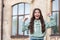 Excited teen girl in casual shouting making winning gesture blurry outdoors