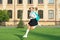 Excited teen girl running to school. Energetic schoolgirl carrying school bag midair. Back to school