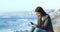 Excited teen reading good news on the beach