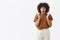 Excited and thrilled speechless african american young girl with curly hairstyle gesturing with palms near chest opening