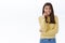 Excited and upbeat young feminine brunette woman in yellow sweater smiling thrilled and overwhelmed, biting finger as