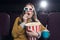 excited woman in 3d glasses eating popcorn and watching movie