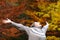 Excited woman celebrating autumn stretching arms