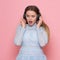 Excited woman dancing and listen to music wearing headphones in pink wall