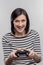 Excited woman feeling curious while holding joystick for video games