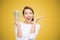 Excited woman holding heap of dollars looking super happy on bright yellow background