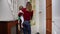 Excited woman and kids open door to Christmas tree