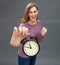 Excited woman raising alarm clock for optimism and winning deadlines