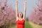 Excited woman raisng arms showing armpit in nature