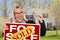 Excited Woman with Sold Sign and Keys in Front of House