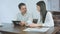 Excited woman telling story to her male coworker holding tablet during coffee break