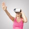 Excited woman with virtual reality glasses on gray