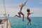 Excited women jumping from boat to swim in the ocean. Cheerful women jumping from boat during cruise to swim in the