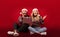 Excited young couple shopping for Christmas gifts with super discounts on laptop computer over red background