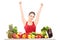 Excited young female gesturing happiness on a table full of fruits and vegetables