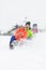 Excited young friends sledding in snow