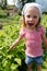 Excited young girl points to the fast growing beans in her vegetable patch