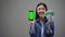 Excited young lady holding smartphone and euro banknotes, online lottery winner