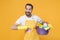 Excited young man househusband in apron rubber gloves doing housework isolated on yellow background. Housekeeping
