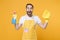 Excited young man househusband in apron rubber gloves hold spray with washing cleanser, cleaning rag while doing