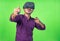 Excited young man with vr or virtual reality headset playing video game on metaverse using joystick on green screen