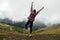 Excited young woman enjoying the view high up in cloudy mountains