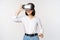 Excited young woman enter virtual reality in her glasses. Asian girl using vr headset, standing over white background