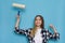 Excited Young Woman Is Holding Paint Roller