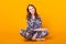 Excited young woman in home wear, widely smiling having fun. Isolated on yellow background.