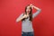 Excited young woman keeping mouth wide open, looking surprised, making hands photo frame gesture isolated on bright red