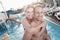 Excited young woman and man embracing in swimming pool