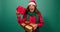 Excited young woman shakes Christmas gifts, guessing what is inside, Studio