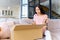 Excited young woman unpacking huge carton box