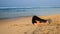 Exciting barefoot lady lies on yellow sand in yoga position