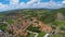 Exciting landscape of Italian village lying near grassy hill under blue sky