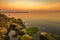 Exciting sea sunset at warm colors and colorful moss over the rocks.