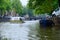 Excursion pleasure boat on canal in city center, rainy day, Amsterdam, Netherlands