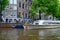 Excursion pleasure boat on canal in historic center of city, Amsterdam, North Holland, Netherlands