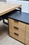 Executive desk of oak veneer with dark grey enamel in office